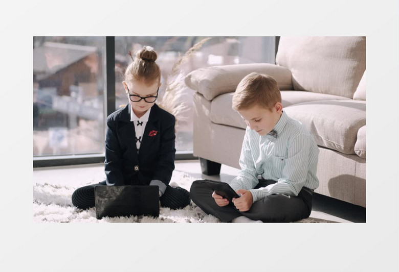 两个小朋友坐在地毯上玩电子产品实拍视频素材