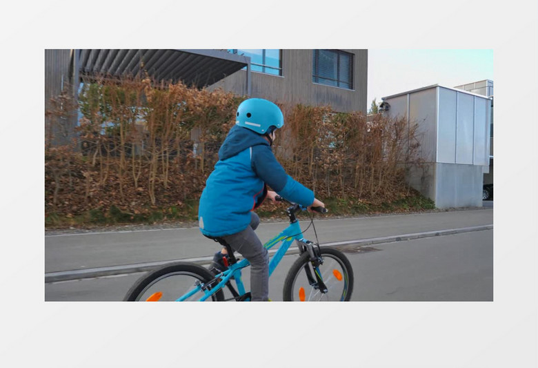 小男孩戴着蓝色头盔骑自行车实拍视频素材