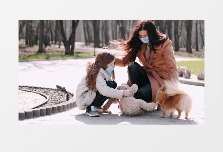 妈妈陪着小女孩在跟狗狗玩耍实拍视频素材