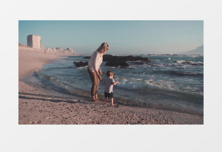 陪着宝宝在海边冲浪的妈妈实拍视频素材