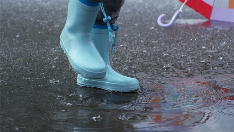 小女孩在雨中踩水实拍视频素材