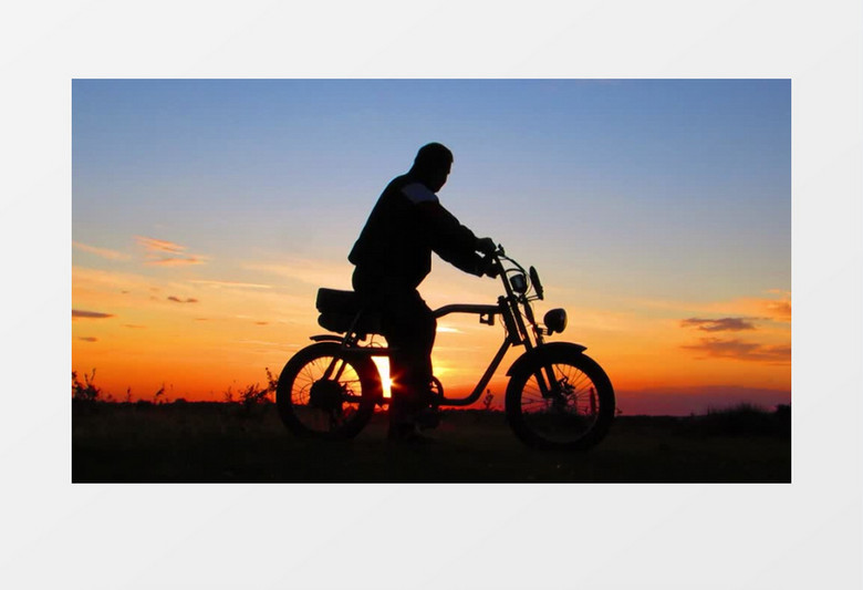 一个男人在夕阳的余晖下骑坐在自行车上实拍视频素材