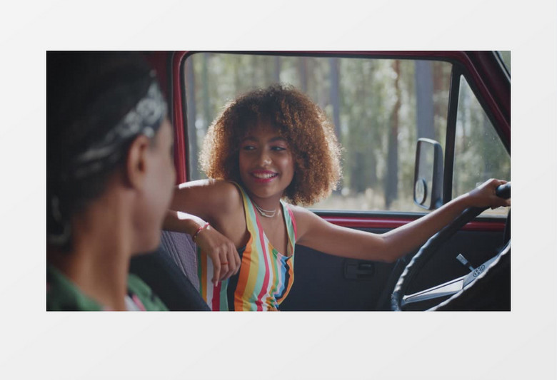 爆炸头女孩在车内跟朋友交谈实拍视频素材