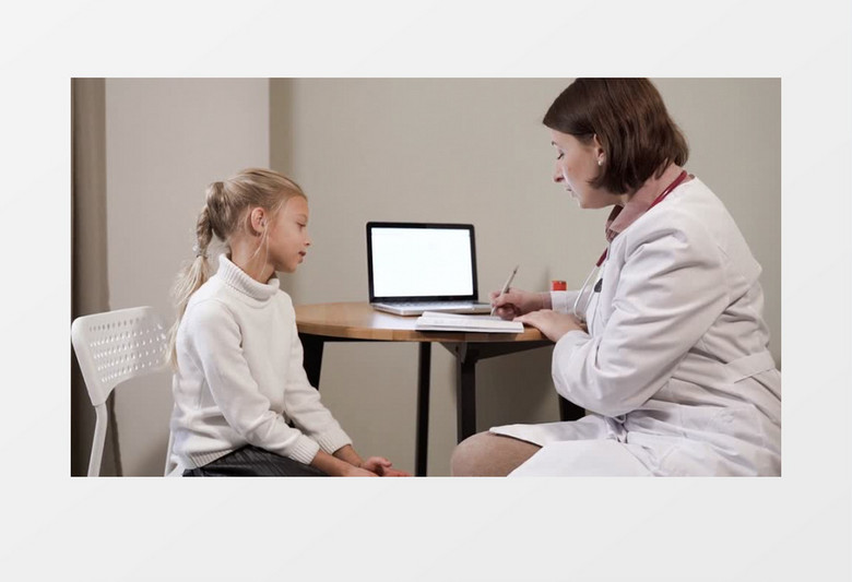 女医生坐在桌前给女孩问诊写病例实拍视频素材