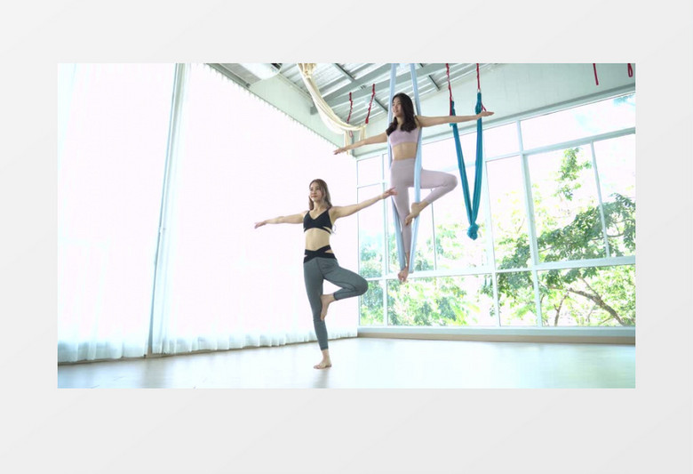 两位女孩正在做空中瑜伽运动实拍视频