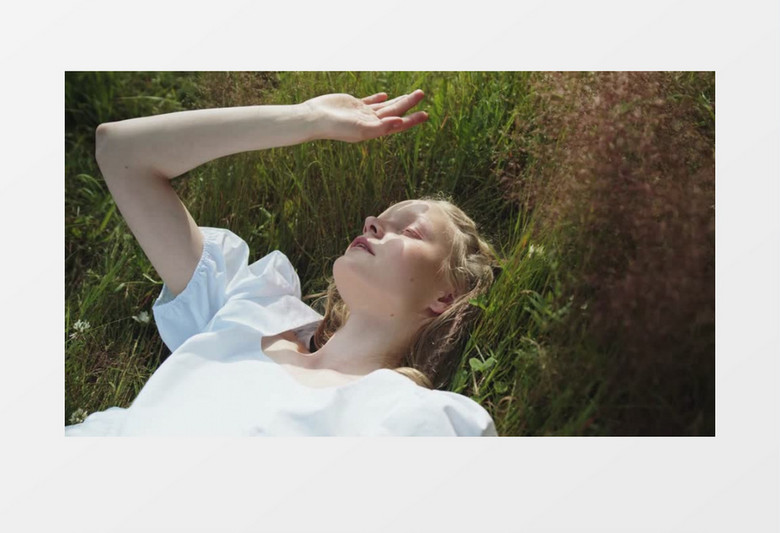 白裙女人躺在草丛中沐浴阳光实拍视频素材