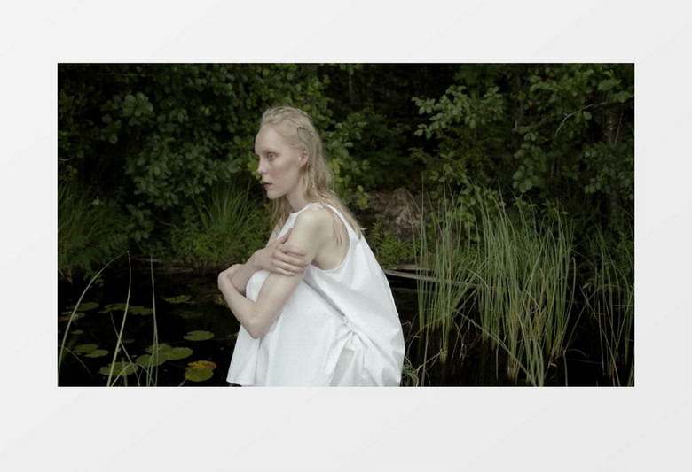 白裙子女人在池塘边抱腿蹲坐实拍视频素材