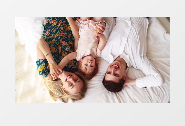 俯拍一家人开心的躺在床上实拍视频素材