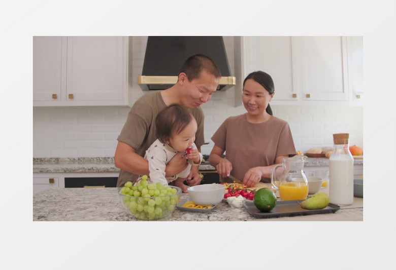 爸爸抱着孩子在厨房宝宝拿起桌子上的圣女果实拍视频素材