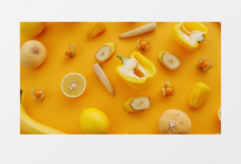 俯拍黄色的桌面上放了许多切开的水果和蔬菜实拍视频
