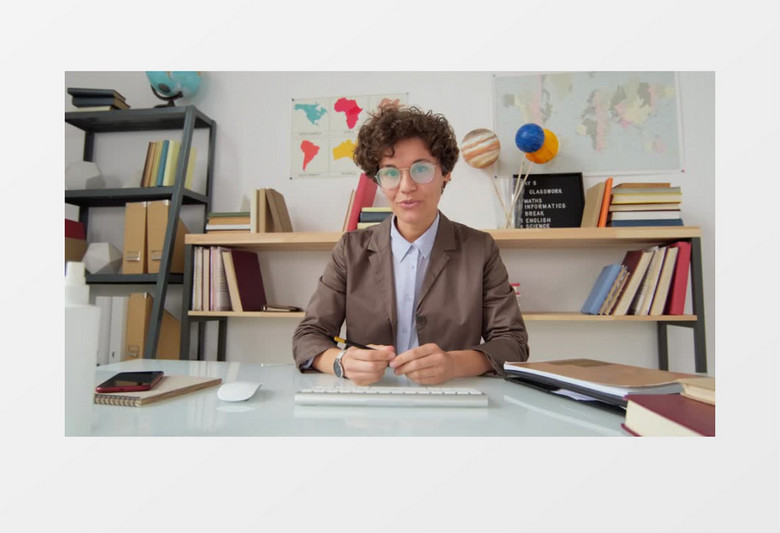 一个戴着眼镜的女老师在书架前给学生上网课实拍视频素材