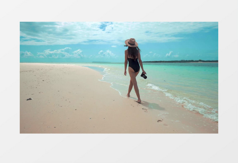 女人穿着比基尼拿着相机走在海边实拍视频素材