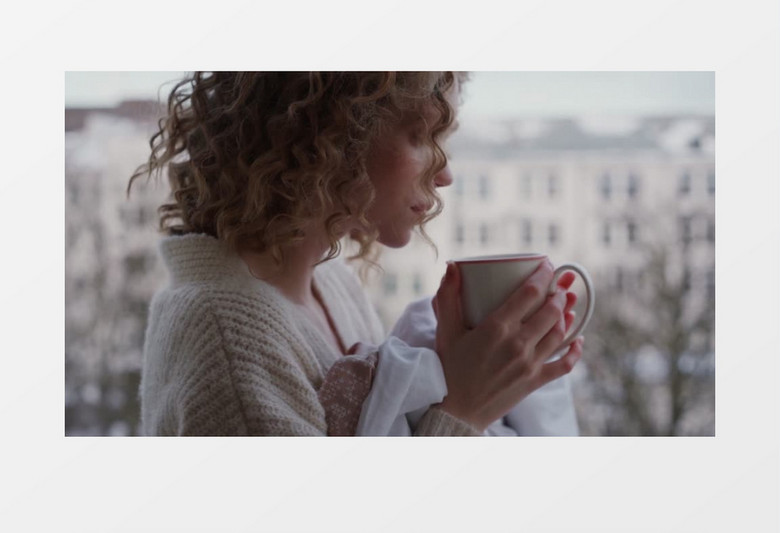 女人抱着杯子喝杯子中的热饮实拍视频素材