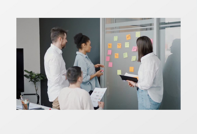 两个女白领在跟同事讨论并贴便利贴记录实拍视频素材