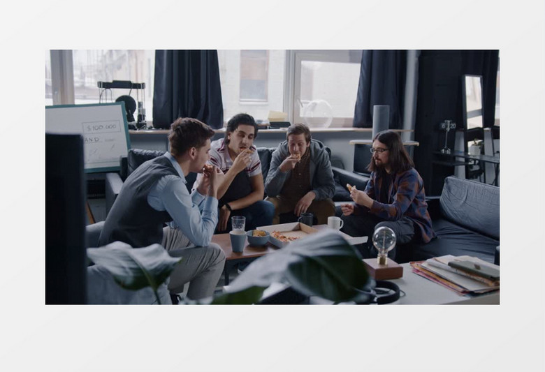 四人小组在办公室吃披萨实拍视频素材