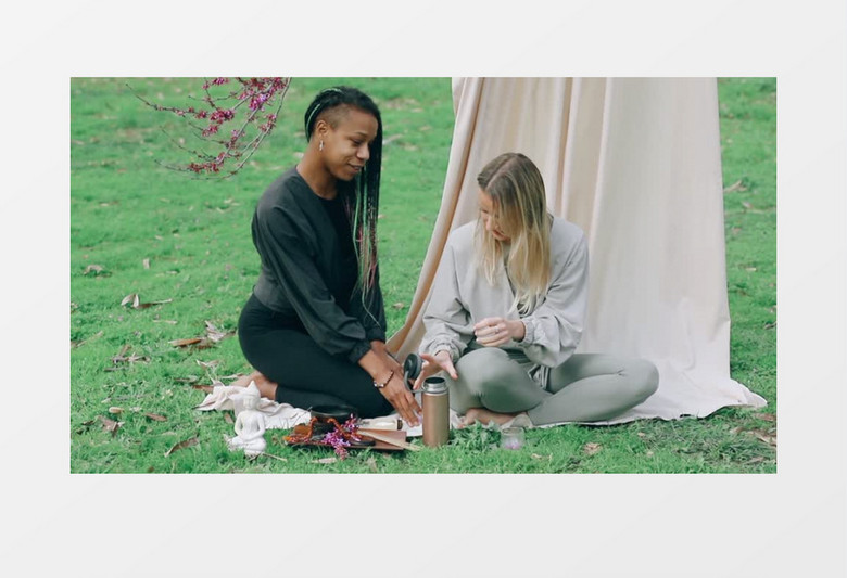 两个女人坐在草地上喝茶实拍视频素材