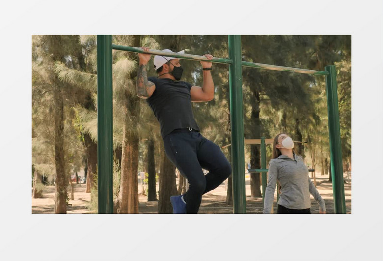 一男一女正在公园健身设备做引体向上实拍视频