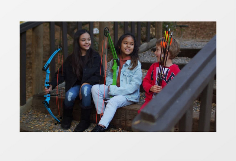 三个小孩手拿弓弩和箭坐在楼梯上开心大笑实拍视频