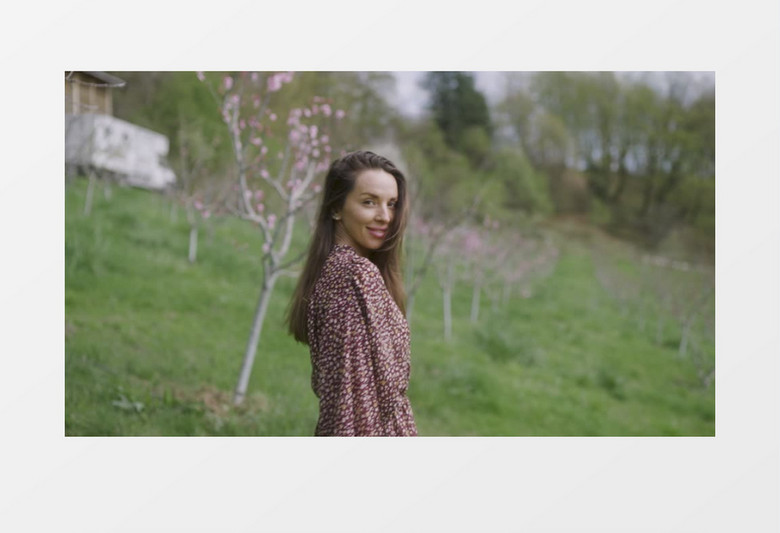 女子在桃花林里微笑回头实拍视频