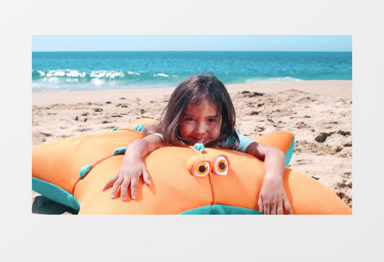 海滩上有个女孩趴在海星抱枕上实拍视频