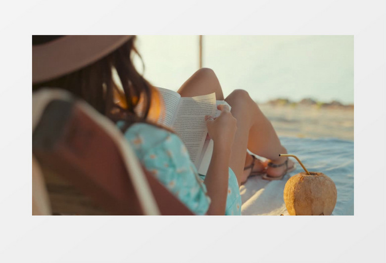 女孩在海边的躺椅上看书实拍视频
