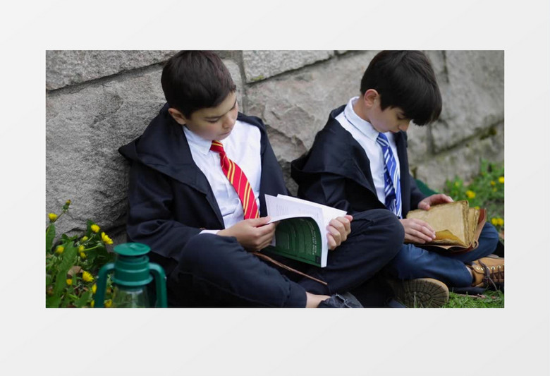 两个男孩坐在墙角翻看书籍实拍视频素材