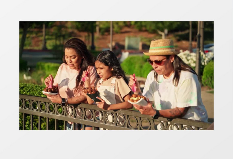 一家人倚靠在围栏上吃冰激凌实拍视频素材