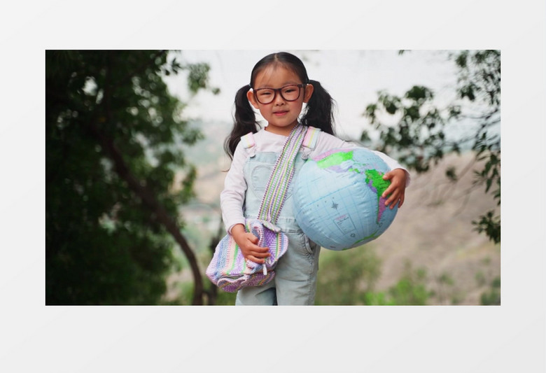 戴眼镜的小女孩抱着地球仪抱枕实拍视频素材