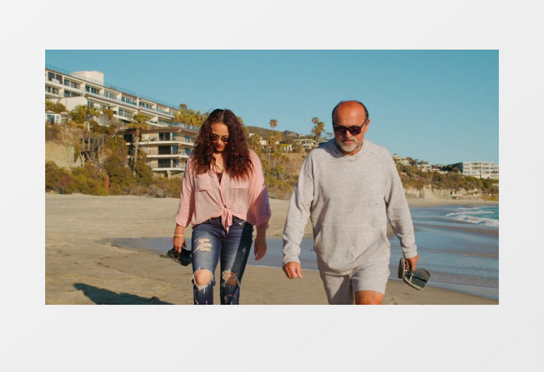 一对情侣在海边沙滩上漫步实拍视频素材