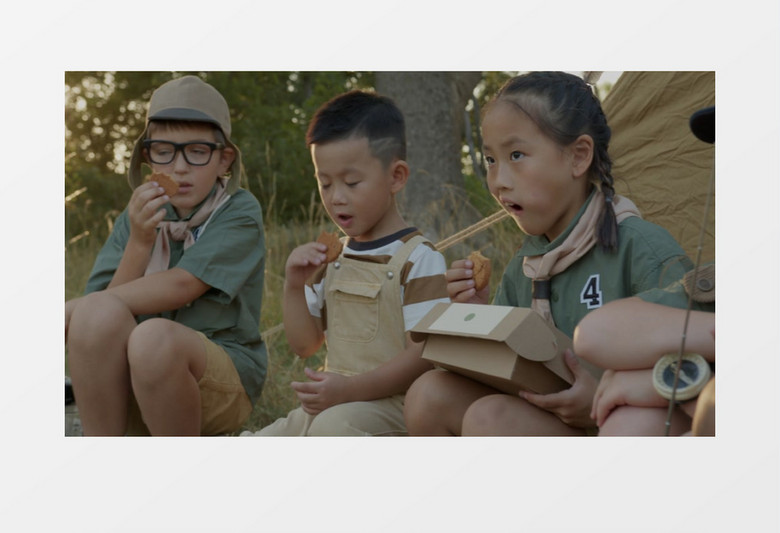 几个小朋友坐在帐篷前吃饼干实拍视频素材