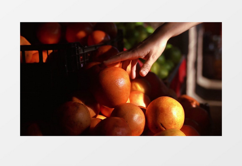 顾客在水果摊前挑选橙子实拍视频素材