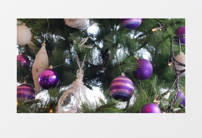 绿色的圣诞树上挂满了飘落的装饰彩球实拍视频素材