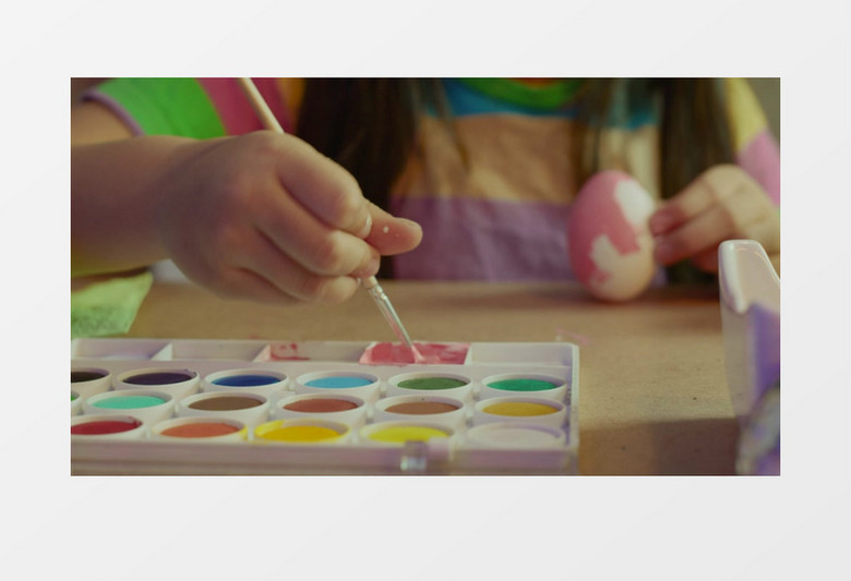 小女孩在蘸取颜料给鸡蛋涂色实拍视频素材