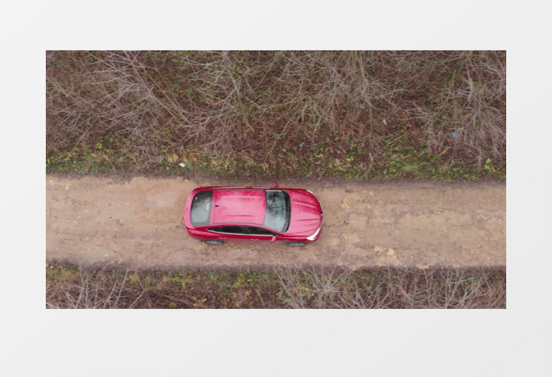 一辆红色的汽车行驶在郊外的小路上实拍视频素材