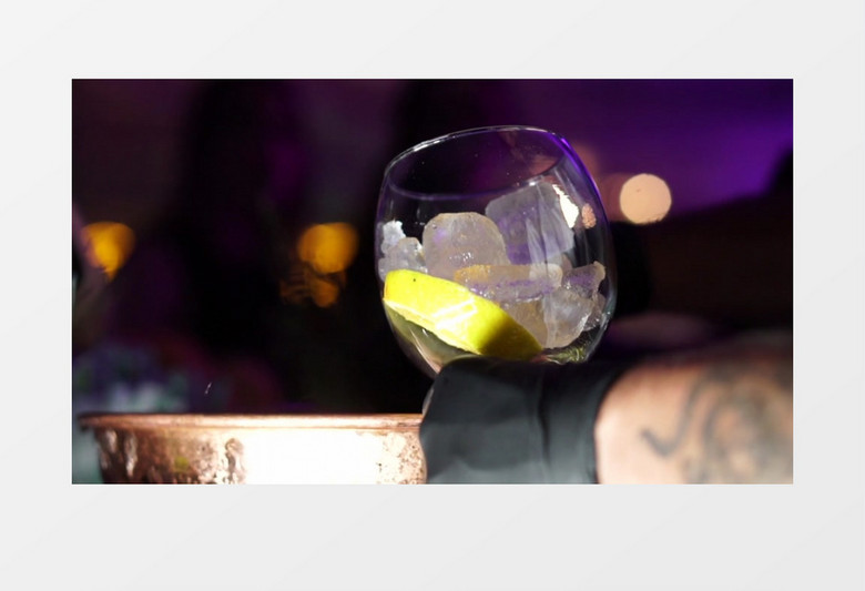 调酒师在酒杯中加入柠檬片和冰块实拍视频素材