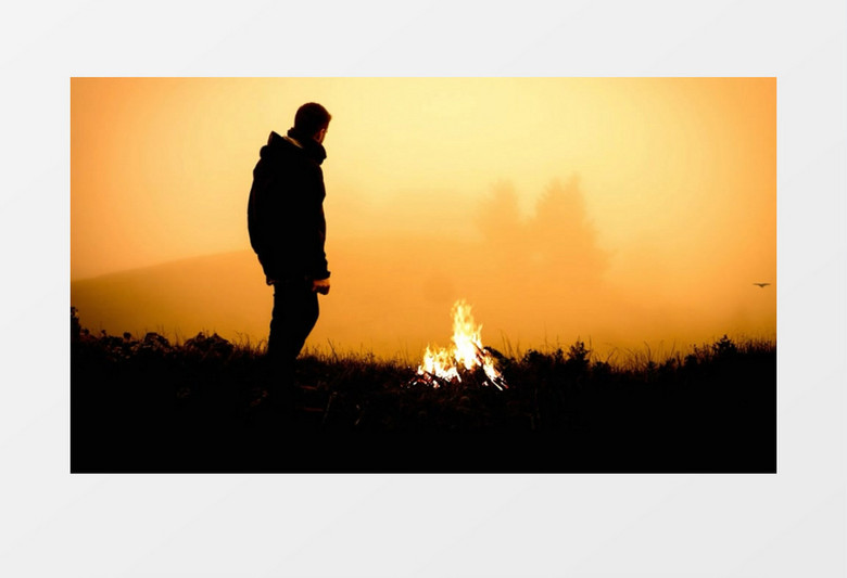 男人站在山顶上点着篝火眺望远方实拍视频素材