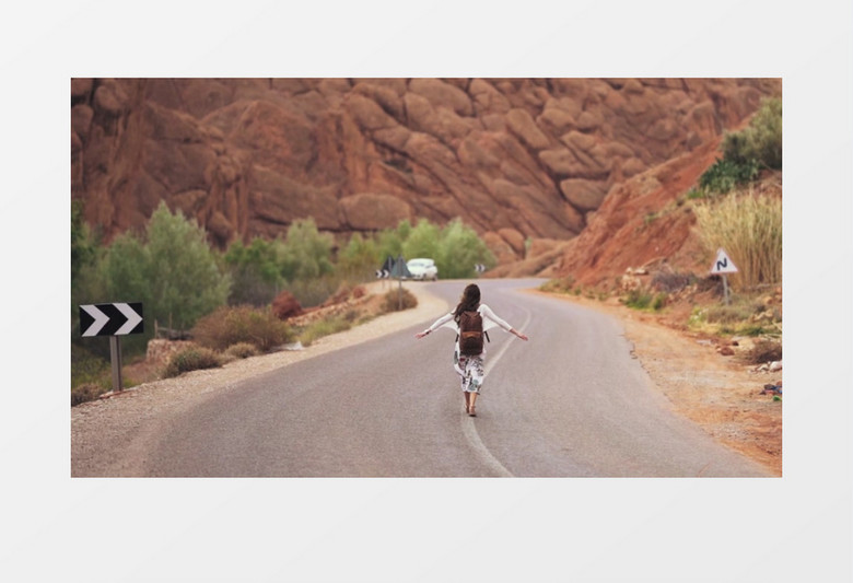 美女背包漫步在山脚下的道路上实拍视频素材实拍视频素材
