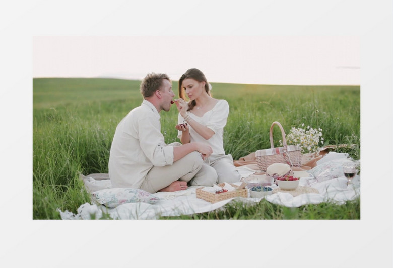 一对情侣在郊外的草地上野餐实拍视频素材