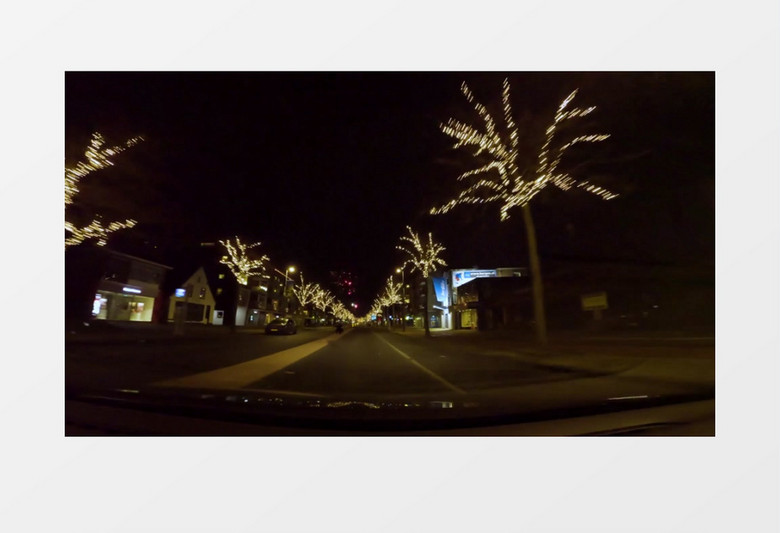 汽车缓缓行驶在有树灯的街道实拍视频素材