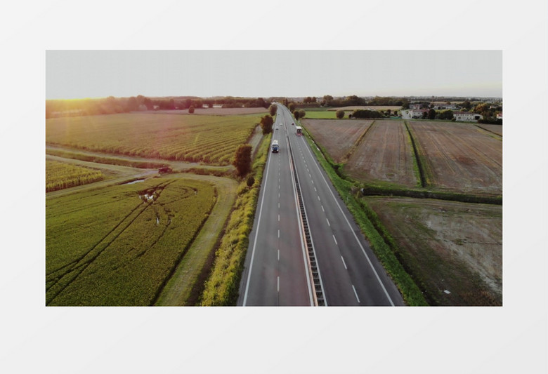 航拍公路上飞驰的汽车及两侧的田地实拍视频素材