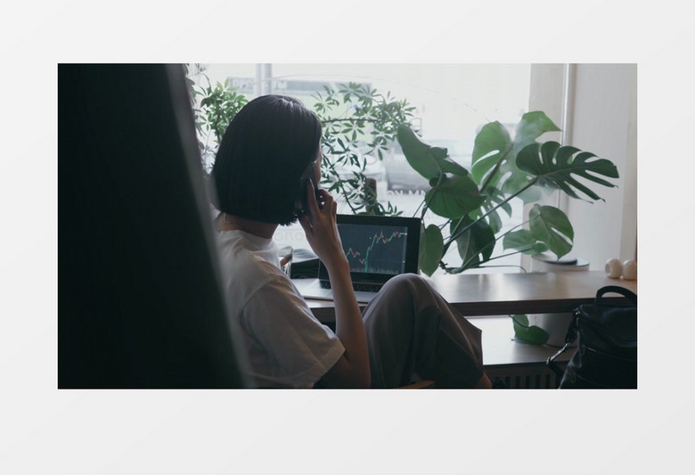 女士边看股票变化边打电话实拍视频素材