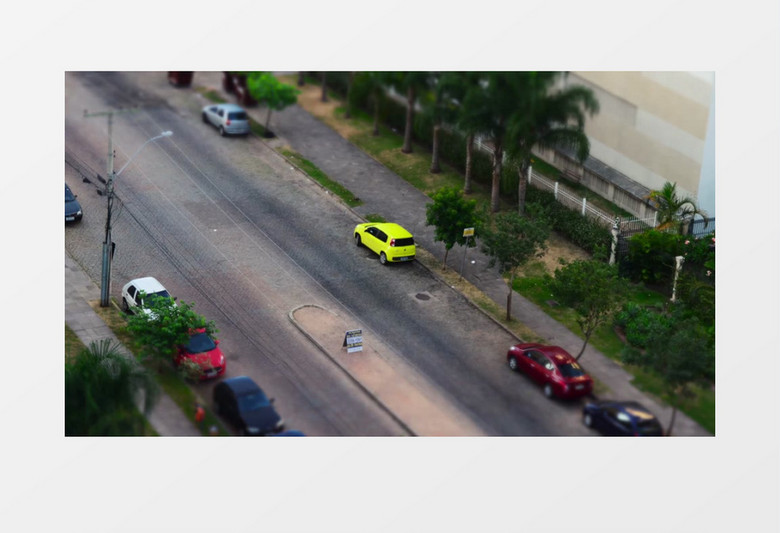 黄色的小汽车在街边飞驰实拍视频