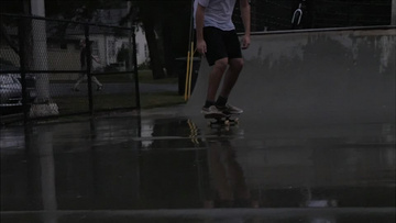特写慢动作下雨天滑冰者滑滑板实拍视频素材